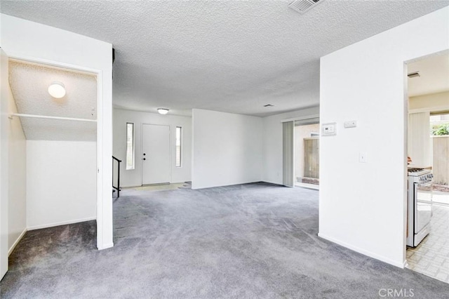 unfurnished living room with visible vents, carpet, and a textured ceiling