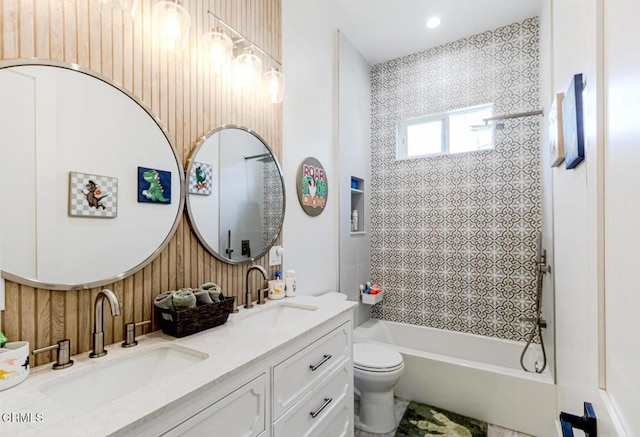 bathroom with a sink, shower / bathing tub combination, toilet, and double vanity