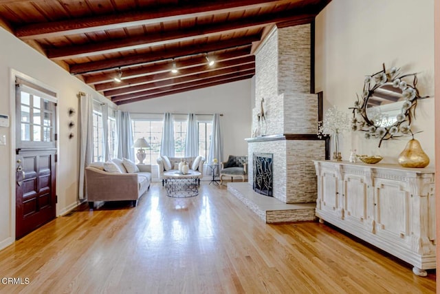 living area with plenty of natural light, lofted ceiling with beams, wooden ceiling, and light wood-type flooring