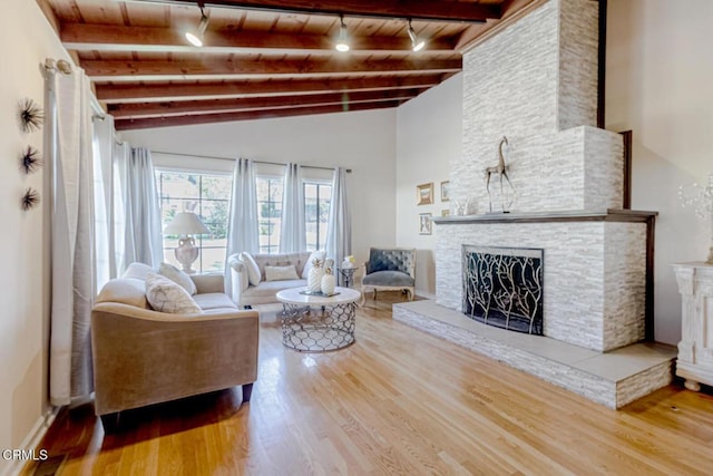 living area featuring track lighting, wood finished floors, a fireplace, wood ceiling, and lofted ceiling with beams