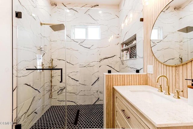 bathroom with a marble finish shower and vanity