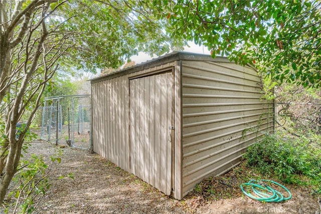 view of shed featuring fence