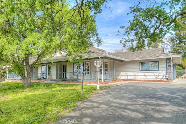 ranch-style house featuring a porch and a front lawn