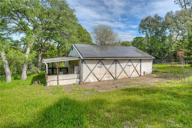 view of outdoor structure featuring fence and an outbuilding