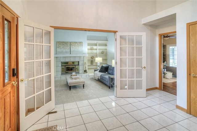 interior space with light tile patterned floors, french doors, and a towering ceiling