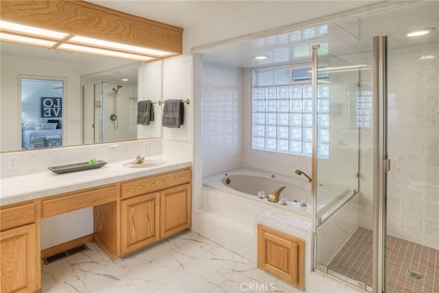 ensuite bathroom with a stall shower, marble finish floor, visible vents, a garden tub, and vanity