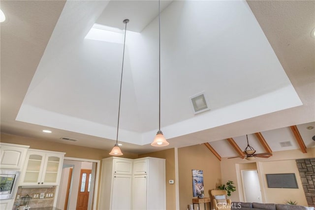 details featuring white cabinets, visible vents, and hanging light fixtures