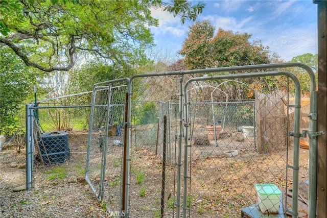 view of gate with fence and central AC