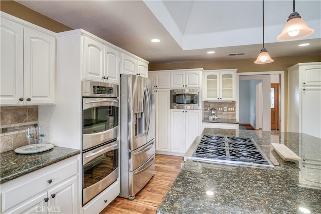 kitchen featuring dark stone counters, white cabinets, appliances with stainless steel finishes, tasteful backsplash, and recessed lighting