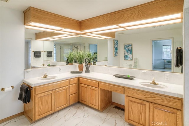 full bath featuring a sink, double vanity, and marble finish floor