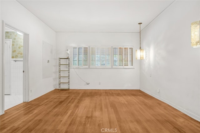spare room featuring wood finished floors and baseboards