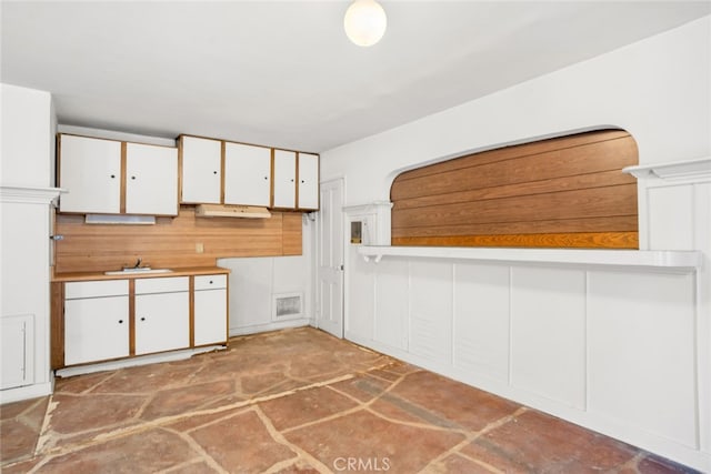 kitchen featuring a sink, white cabinetry, and visible vents