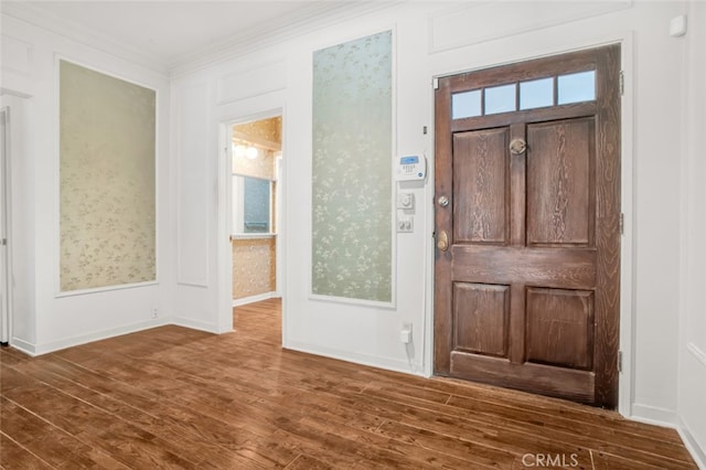 foyer entrance with crown molding, dark wood-style flooring, and baseboards