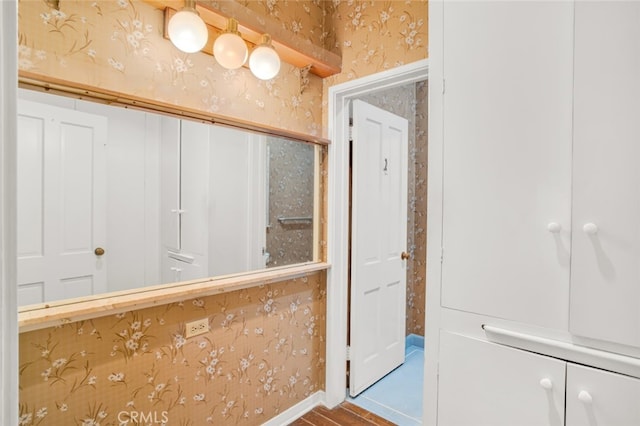 bathroom with baseboards and wallpapered walls