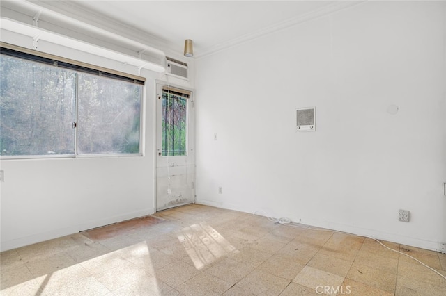 unfurnished room featuring crown molding, baseboards, and tile patterned floors
