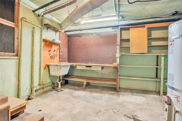 unfinished below grade area featuring water heater and a workshop area