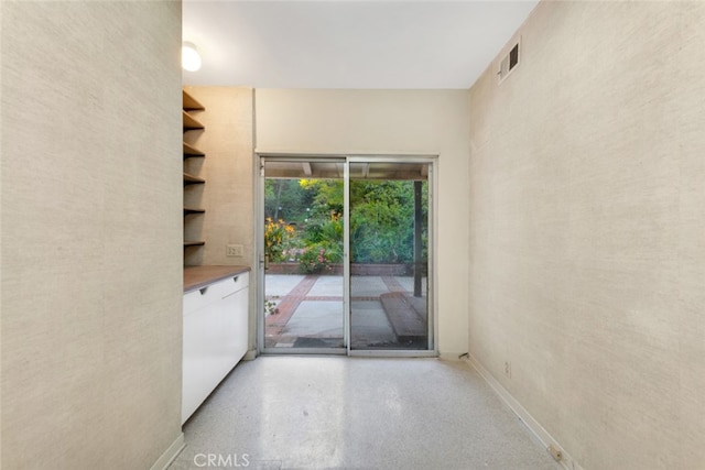entryway featuring visible vents, baseboards, and light speckled floor