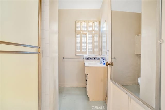 full bath with toilet, vanity, finished concrete flooring, and walk in shower