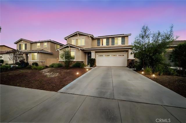 view of front facade with a tiled roof, a garage, driveway, and stucco siding