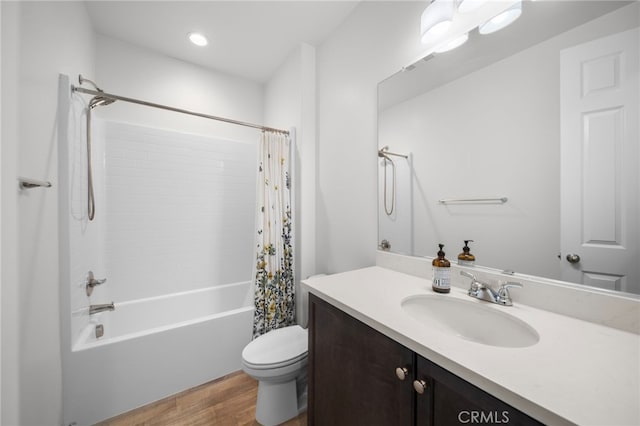 full bath featuring toilet, shower / bath combo, vanity, and wood finished floors