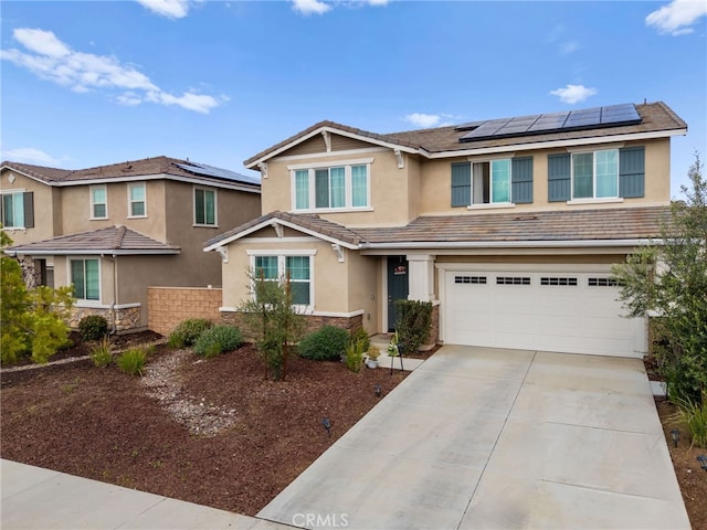 view of front of house with a garage, concrete driveway, solar panels, a tile roof, and stucco siding