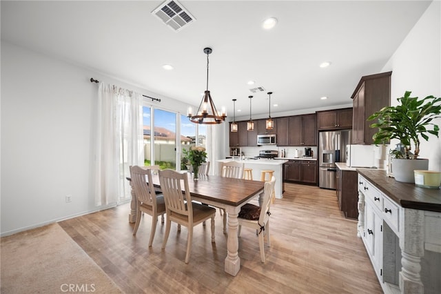 dining area featuring recessed lighting, visible vents, a notable chandelier, and light wood-type flooring