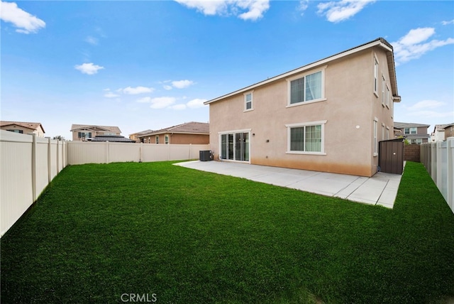back of house with a fenced backyard, stucco siding, a patio area, and a lawn