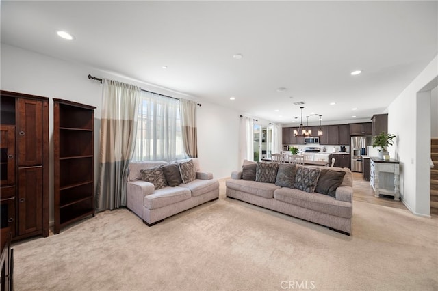 living room featuring an inviting chandelier, light carpet, and recessed lighting