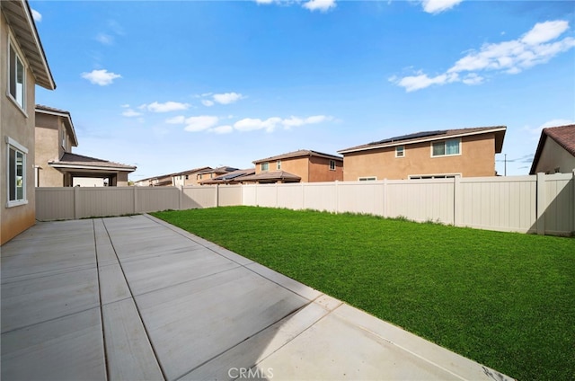 view of yard with a fenced backyard, a residential view, and a patio