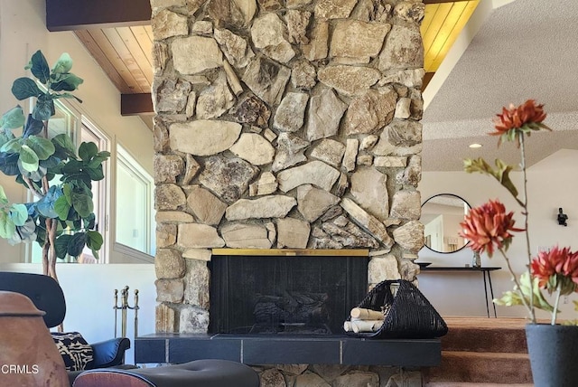 interior space featuring beam ceiling and a stone fireplace