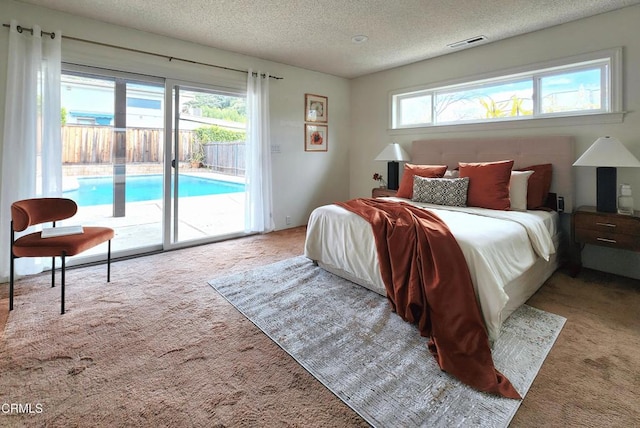bedroom with visible vents, a textured ceiling, carpet floors, and access to exterior