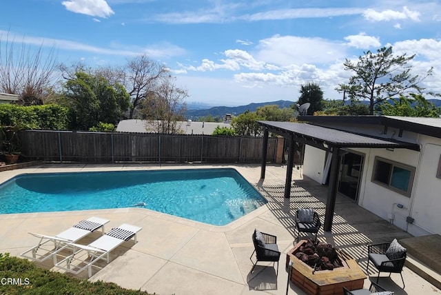 view of pool with a fenced in pool, a patio area, fence, and a mountain view