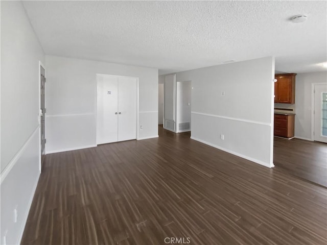 4739 Belmont Pl, Chino, CA 91710 - unfurnished living room featuring a textured ceiling, dark wood-type flooring, and baseboards