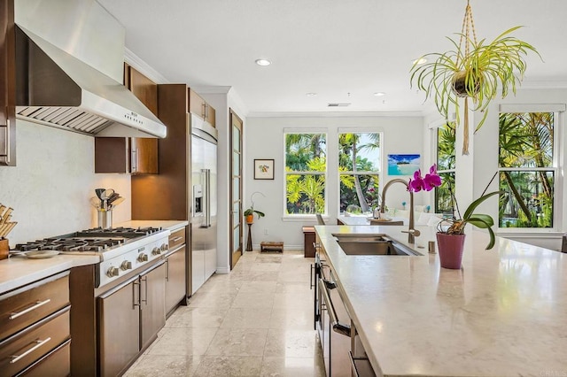 6497 Wayfinders Ct, Carlsbad, CA 92011 - kitchen with wall chimney range hood, gas cooktop, crown molding, built in fridge, and recessed lighting