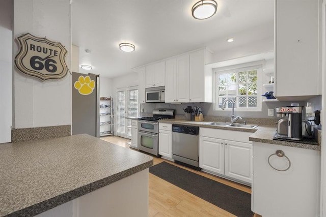 3168 Florine Dr, Lemon Grove, CA 91945 - kitchen featuring appliances with stainless steel finishes, a sink, healthy amount of natural light, and white cabinetry