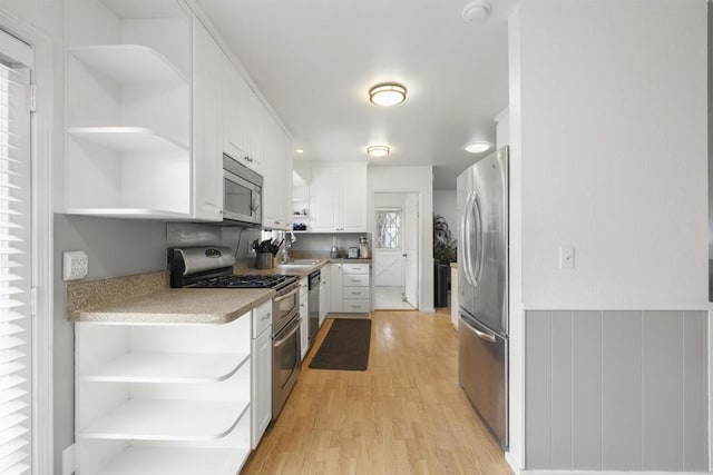 3168 Florine Dr, Lemon Grove, CA 91945 - kitchen with open shelves, stainless steel appliances, white cabinets, and light wood-type flooring