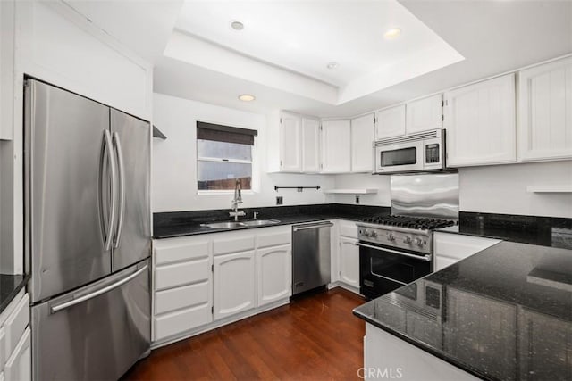 210 39th St, Newport Beach, CA 92663 - kitchen featuring appliances with stainless steel finishes, a sink, a tray ceiling, dark stone countertops, and recessed lighting