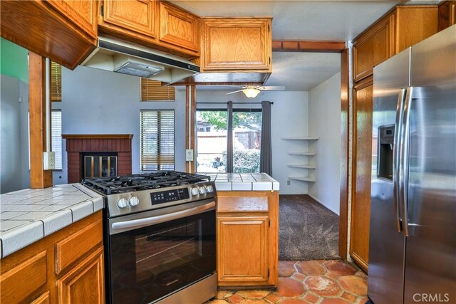 2003 Springcreek Cir, Upland, CA 91784 - kitchen with appliances with stainless steel finishes, tile countertops, ceiling fan, under cabinet range hood, and brown cabinetry