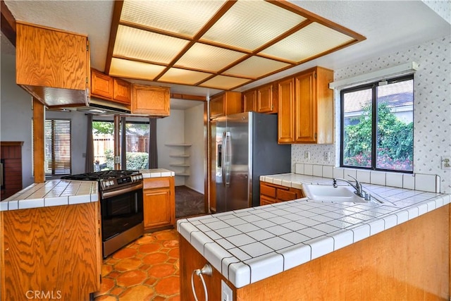 2003 Springcreek Cir, Upland, CA 91784 - kitchen featuring appliances with stainless steel finishes, a sink, brown cabinets, a peninsula, and wallpapered walls