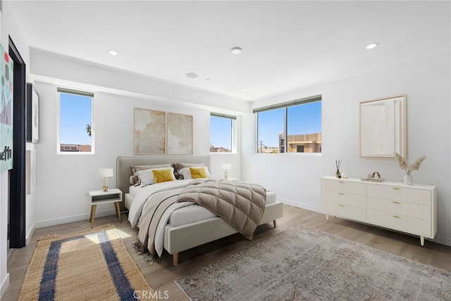 bedroom with baseboards, light wood finished floors, and recessed lighting