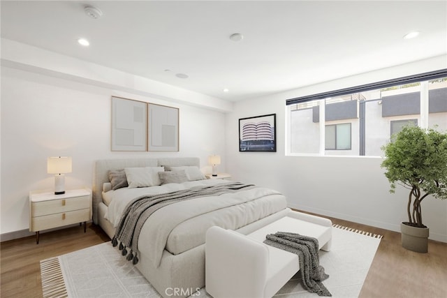 bedroom featuring baseboards, light wood-style flooring, and recessed lighting