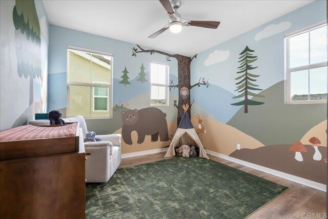 bedroom featuring wood finished floors, baseboards, and ceiling fan
