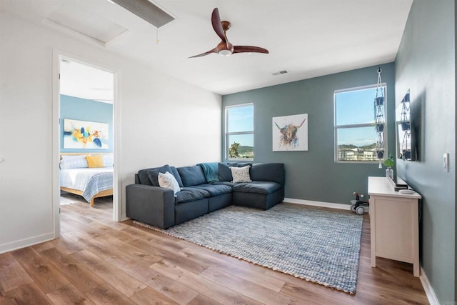 living area featuring ceiling fan, baseboards, wood finished floors, and visible vents