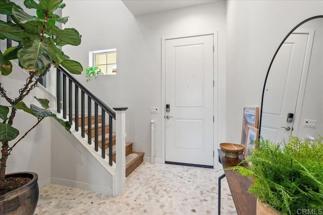 entryway featuring baseboards and stairway