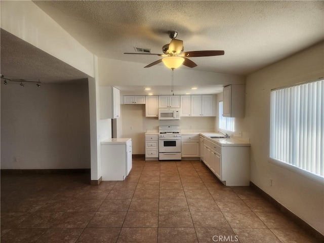 kitchen with a ceiling fan, a textured ceiling, white appliances, lofted ceiling, and visible vents