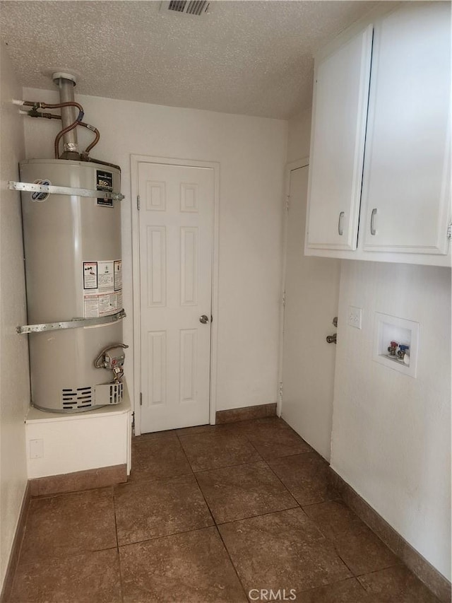 clothes washing area with strapped water heater, baseboards, hookup for a washing machine, and a textured ceiling