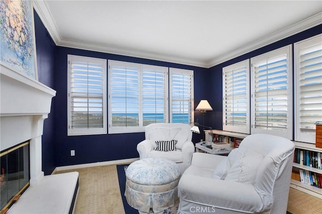 sitting room featuring baseboards, a glass covered fireplace, carpet floors, and ornamental molding
