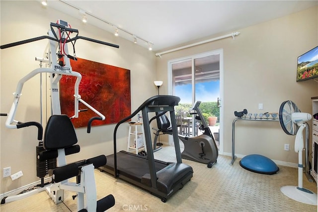 workout room featuring track lighting, carpet flooring, and baseboards