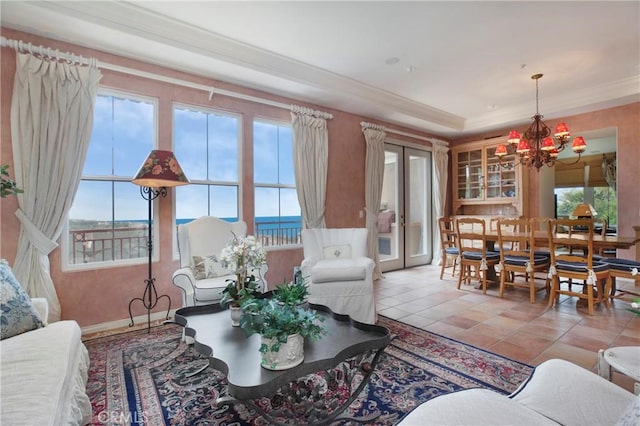living room with tile patterned flooring, crown molding, and a notable chandelier