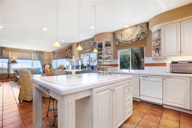 kitchen with open shelves, white dishwasher, tile countertops, and light tile patterned floors